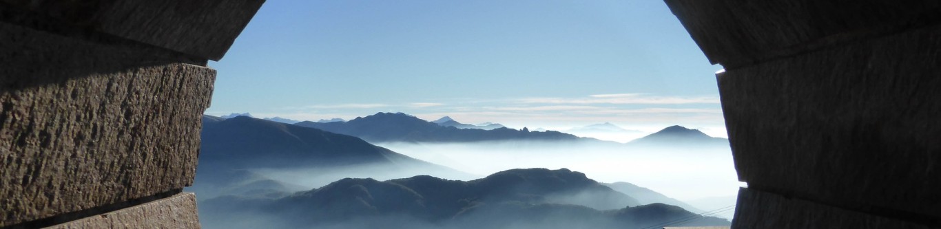 Blick auf Berge im Nebel, der Blick ist links und rechts von einer Mauer begrenzt
